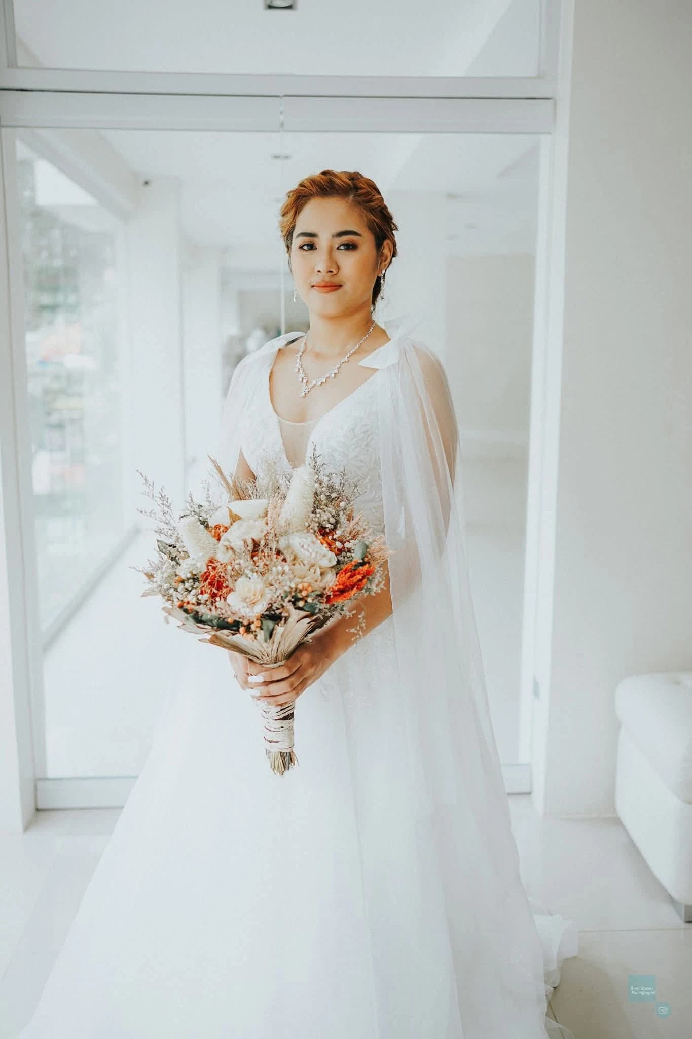Bride holding a bouquet in a bright getting-ready suite