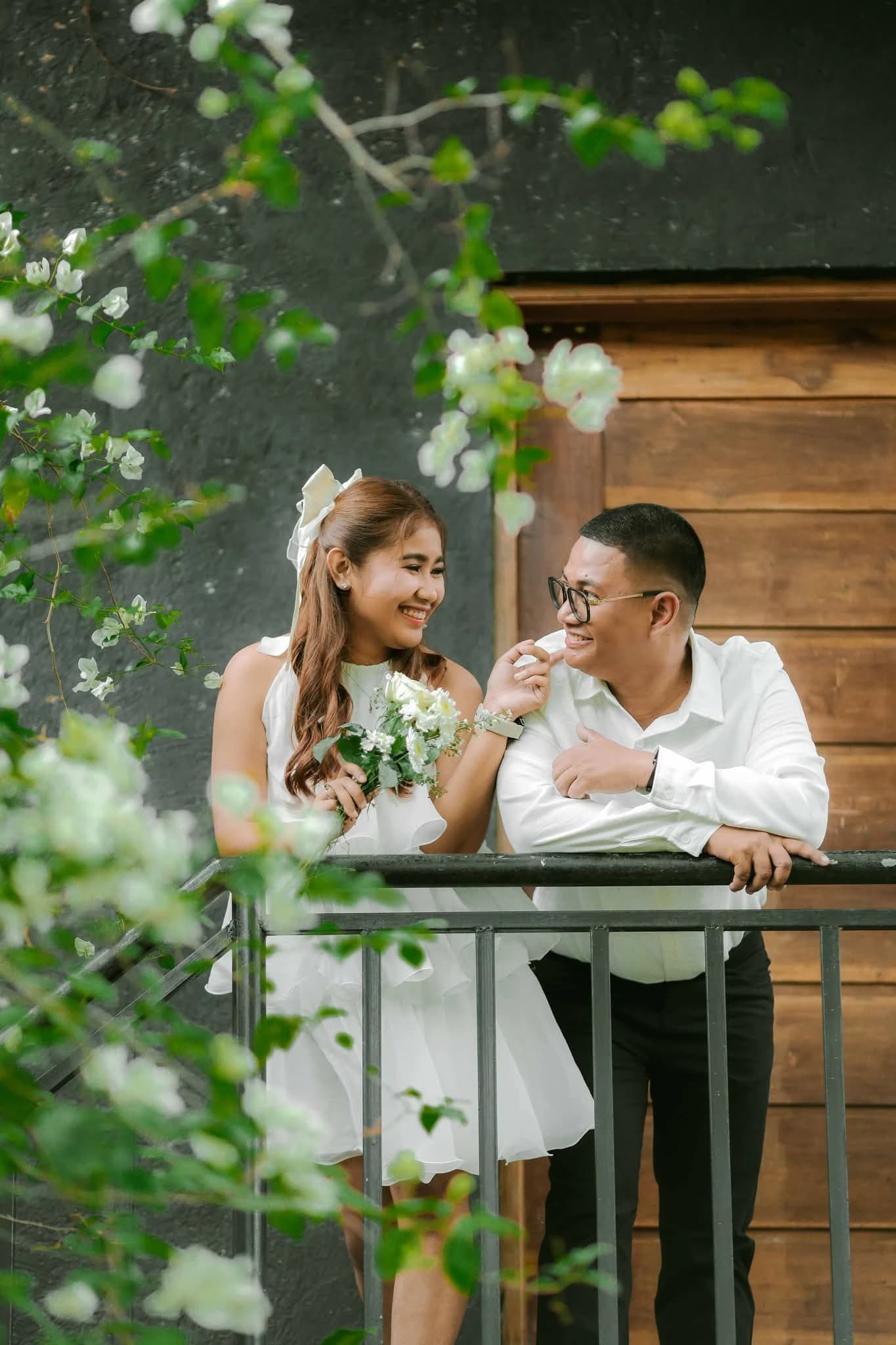 Civil wedding couple sharing a candid moment on a balcony