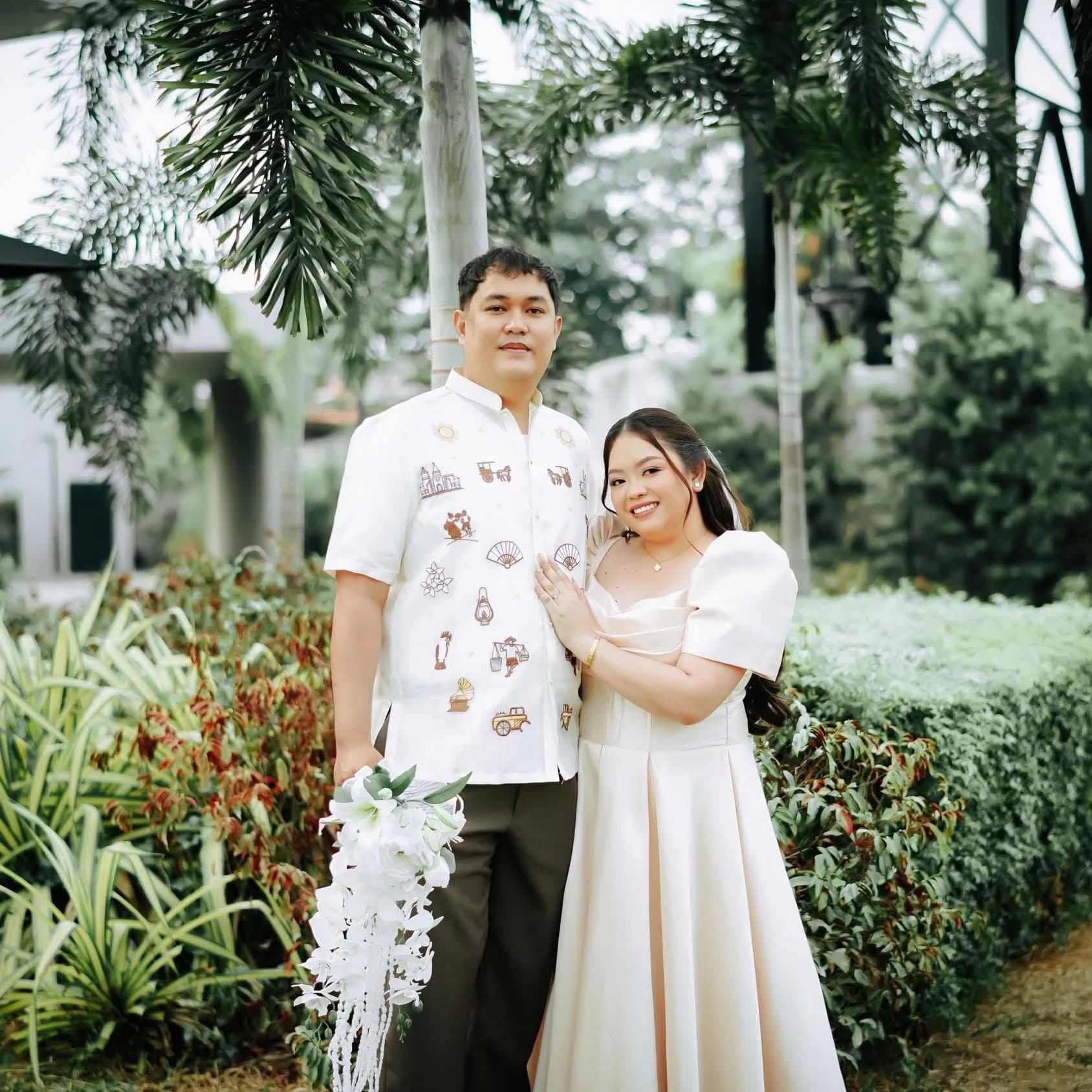 Civil wedding couple in coordinated formal attire posing together in a tropical garden