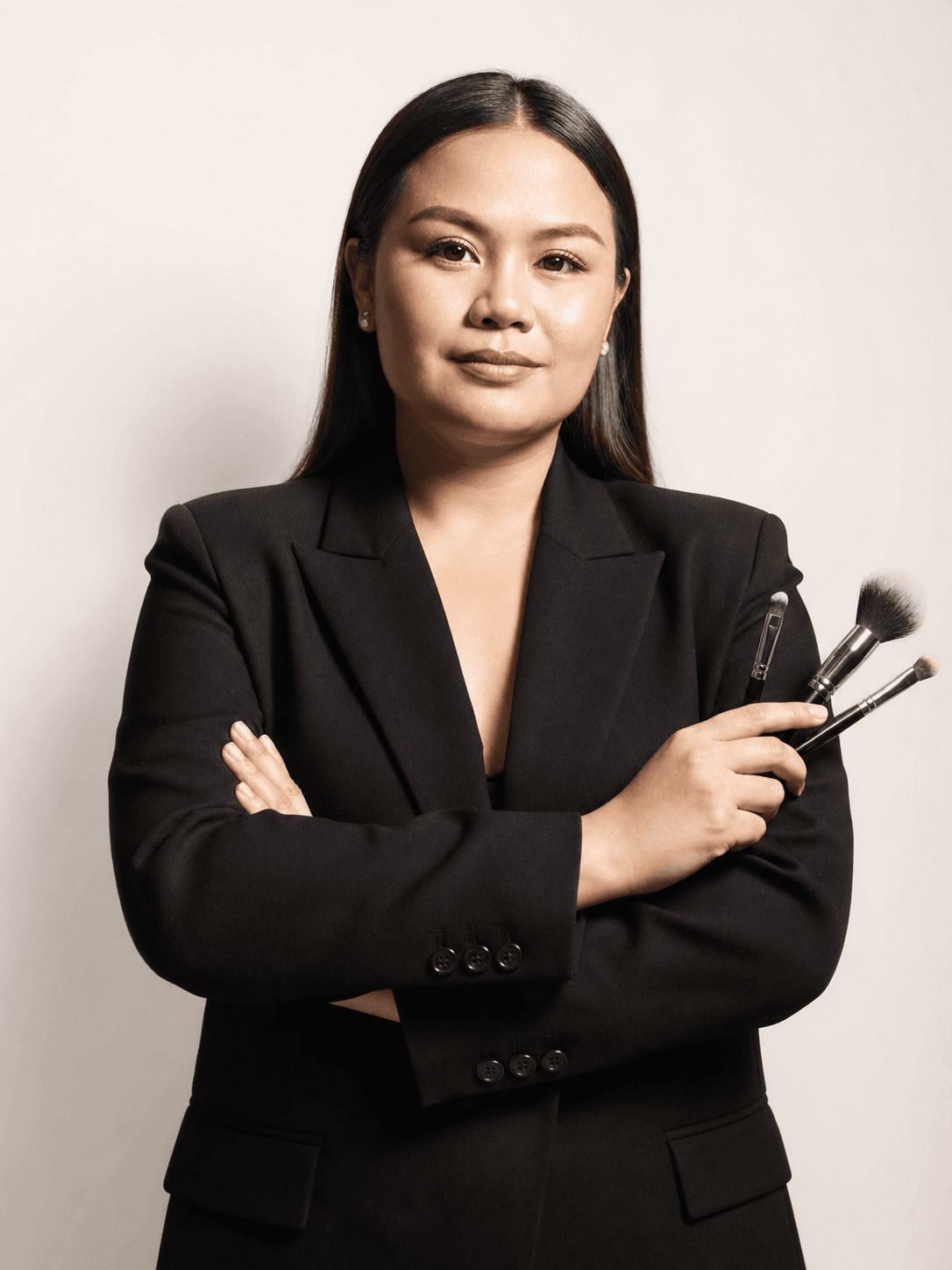Crissa Makeup Artistry artist holding professional makeup brushes