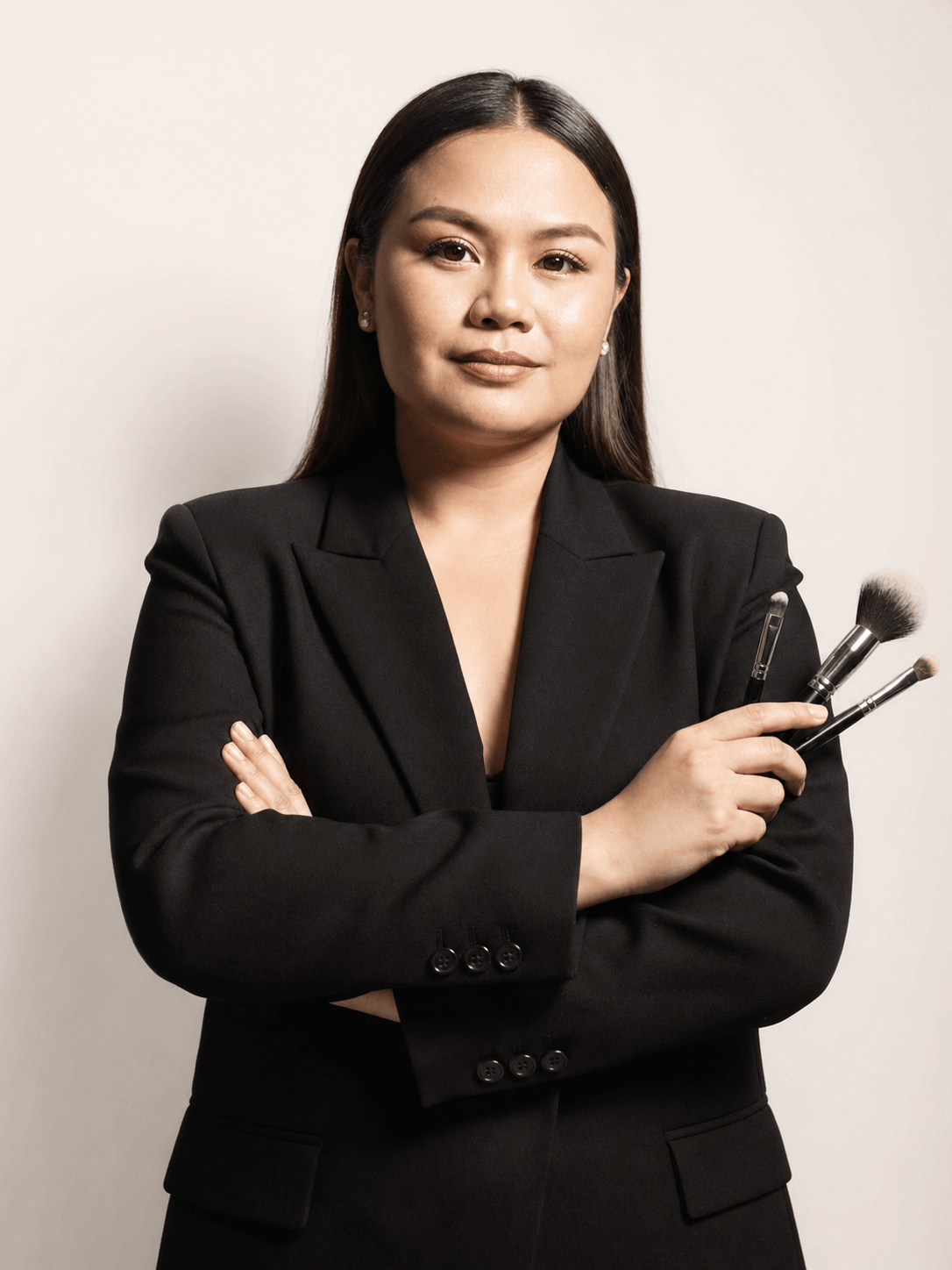 Crissa Makeup Artistry artist holding professional makeup brushes