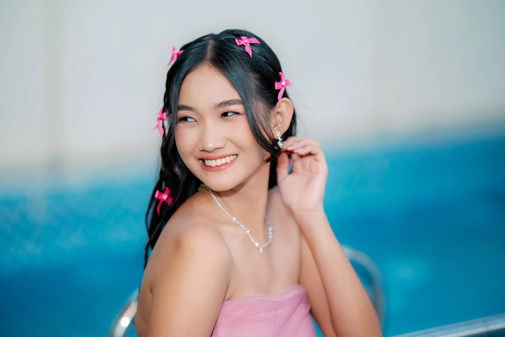 Debutant in a pink gown showing soft polished hair and makeup